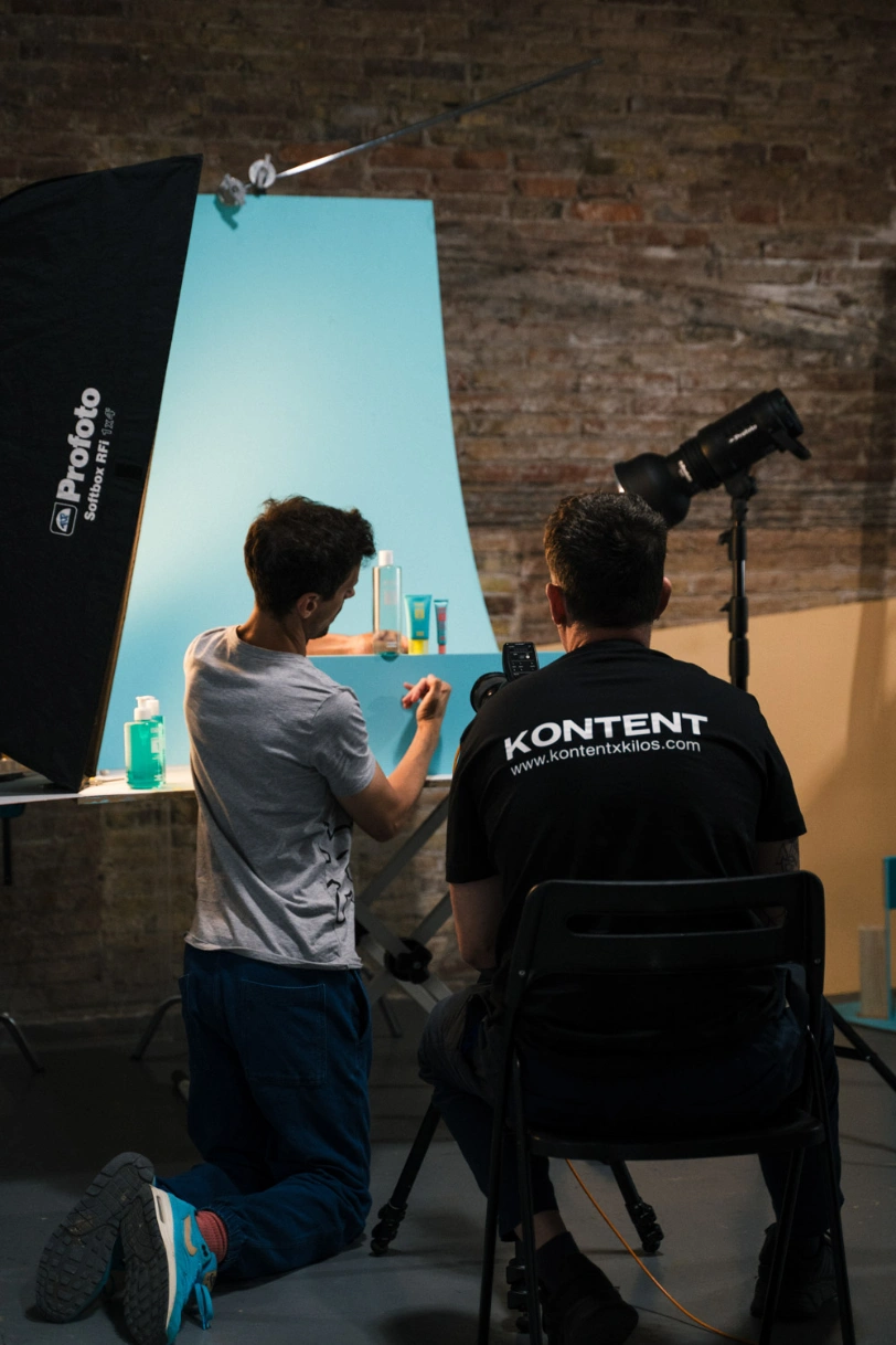 Equipo de KONTENT preparando una foto de producto de cosmética sobre fondo turquesa