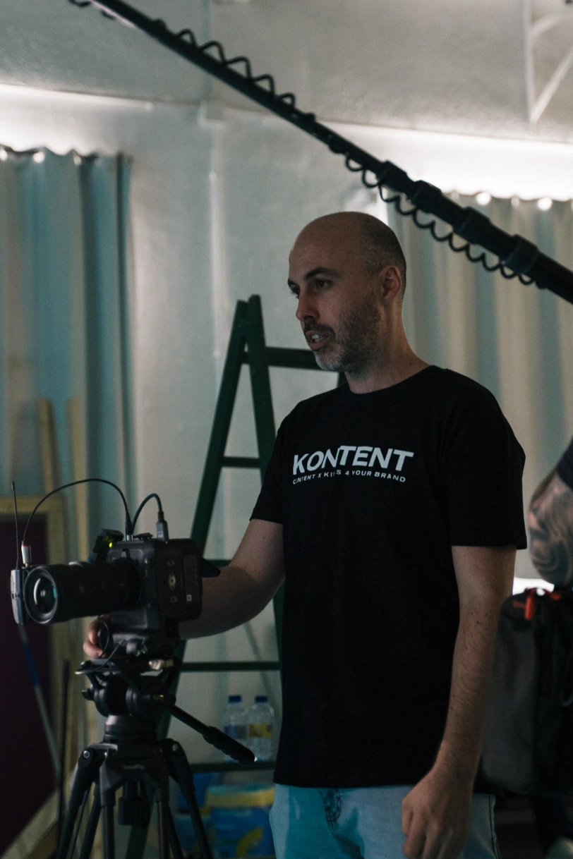 Filmmaker de KONTENT con la camiseta de la marca junto a la cámara, en un rodaje de Glassy